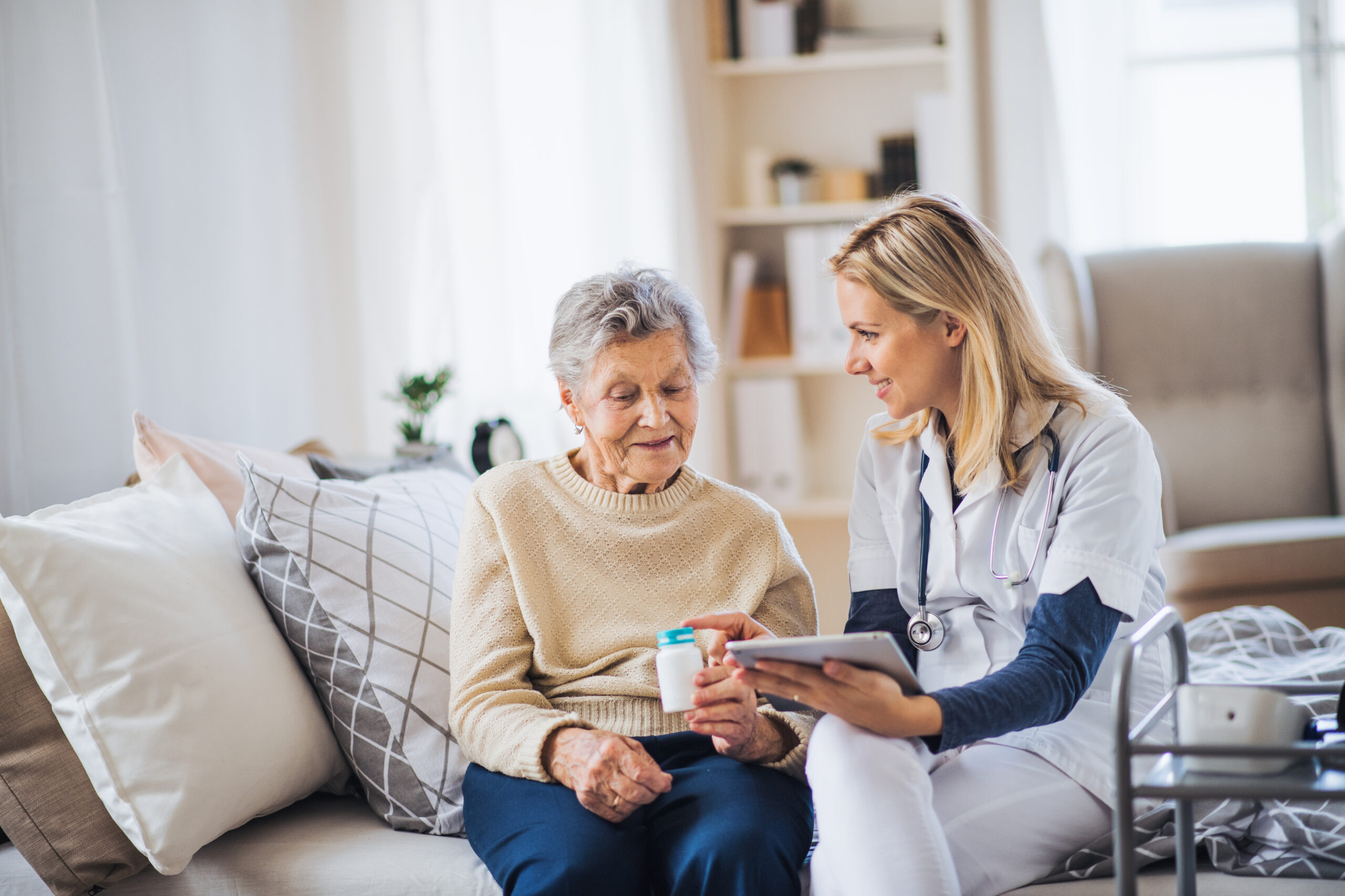A,Health,Visitor,With,Tablet,Explaining,A,Senior,Woman,How